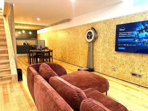 里斯本A casa na Estrela的带沙发的客厅和墙上的电视