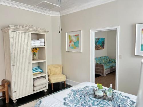 拿骚Downtown Nassau Oasis Unit 1的一间卧室配有一张床、一把椅子和镜子