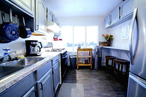 安克雷奇Cozy Private Room With Two Beds的厨房配有蓝色橱柜和水槽