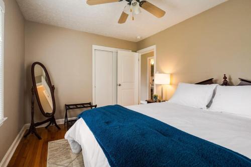 新奥尔巴尼Colonial Village Retreat 2BR的一间卧室配有一张带蓝毯的床和吊扇。