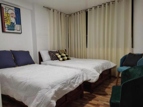 HuantaHOTEL HUANTA - MORENOS的一间卧室配有两张床和椅子