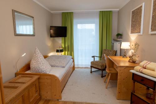 里姆斯廷格Gästehaus Nigglhof的酒店客房配有一张床、一张书桌和一张书桌。