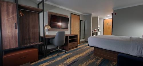 亚基马La Quinta Inn & Suites by Wyndham Yakima Downtown的一间卧室配有一张床和一张带电脑的书桌