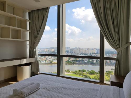 胡志明市Vinhomes Central Park Apartment- Landmark Luxury的卧室设有河景大窗户