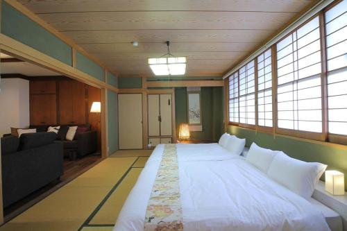 宫岛bHOTEL Kaniwasou 301 Minute walk from Miyajima Pier for 11ppl的窗户客房内的一张大白色床