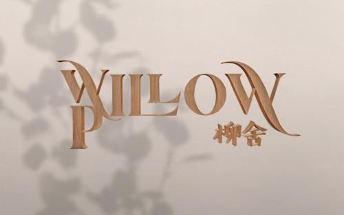 春蓬Willow Pillow Guest House & Poshtel的墙上读柳条的木标志