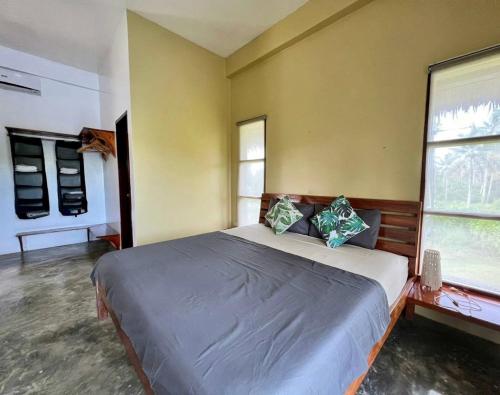 卢纳将军城Siargao Wakepark的一间卧室设有一张大床和两个窗户。