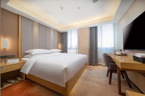 广州Guangzhou Baiyun Airport Yunzhi Hotel near Terminal One的酒店客房配有一张床、一张书桌和一台电脑