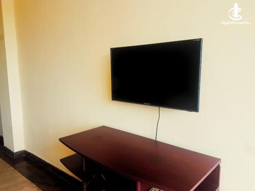 科伦坡Sun City的墙上的平面电视,配有木桌
