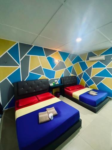 瓜拉大汉Abot guest house的客房设有两张床和彩色墙壁。
