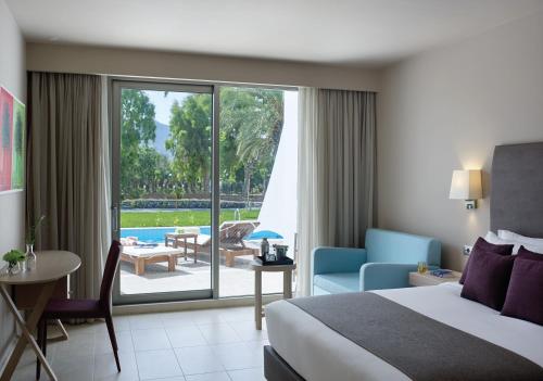 阿默达拉-伊拉克利翁Atlantica Akti Zeus Hotel的酒店客房设有一张床,享有庭院的景色