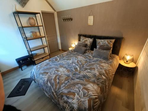 圣让-德蒙Apb-Spa cottages et Apb BnB avec piscine的一间卧室配有一张带枕头的床和两盏灯。