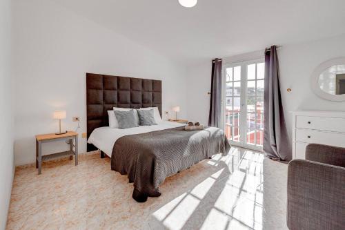 圣胡安海滩Nice House Nina With Jacuzzi的白色的卧室设有一张大床和一个窗户