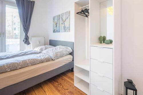 汉堡Cosy 2-room Apartment in urban location的卧室配有白色橱柜和1张床。