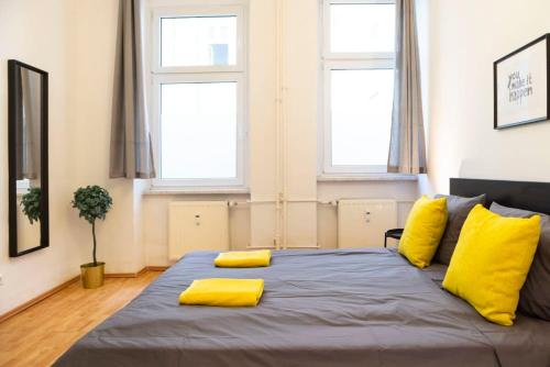 柏林One Bedroom Apartment Berlin Neukölln的一间卧室配有一张带黄色枕头的大床