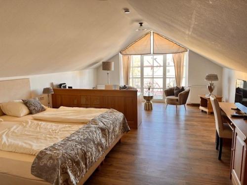 贡岑豪森Posthotel Arnold的一间卧室设有一张大床和一个大窗户