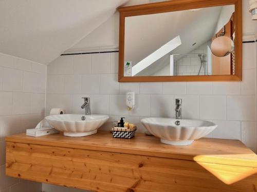贡岑豪森Posthotel Arnold的浴室设有2个水槽和1个镜子