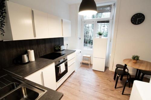 汉堡Great Three Bedroom Apartment的厨房配有白色橱柜、桌子和用餐室。