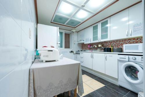 首尔NineRoD - Private bathroom & Shower的厨房配有餐桌上的洗衣机