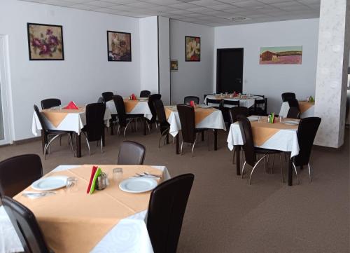 蒂米什瓦拉Hotel vila veneto的一间带桌椅和屏幕的用餐室