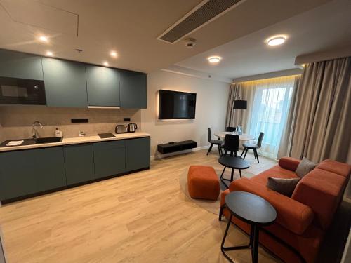 布达佩斯Escala Hotel & Suites的厨房以及带沙发和桌子的客厅。