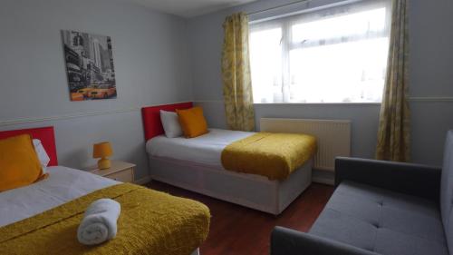Houghton RegisChelsea House-Huku Kwetu Dunstable-3 Bedroom House - Suitable & Affordable -Business Travellers - Group Accommodation - Comfy, Spacious with Lovely Garden Views的一间小卧室,配有两张床和窗户