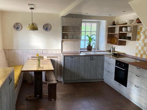 斯托尔河畔希普斯顿Whichford Mill Barn- Soulful retreat.的中间设有带木桌的厨房