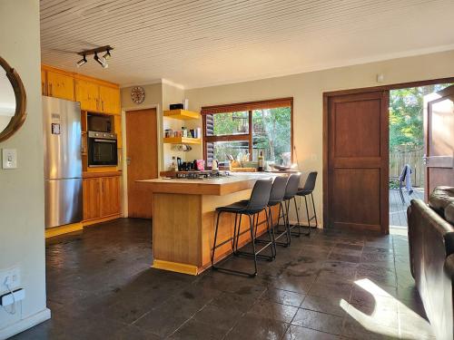 自然谷Nature's Edge Cabin的厨房配有柜台和凳子