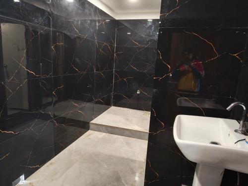 SasarāmAKS INTERNATIONAL HOTEL AND RESORT的一间带水槽和黑色墙壁的浴室