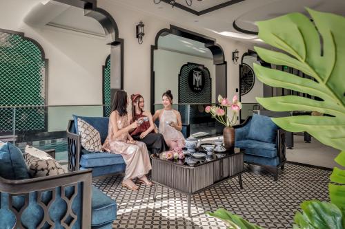头顿T-Maison Indochine Vung Tau Villa near beach FREE pool, billiards, karaoke的一群坐在客厅的三名妇女