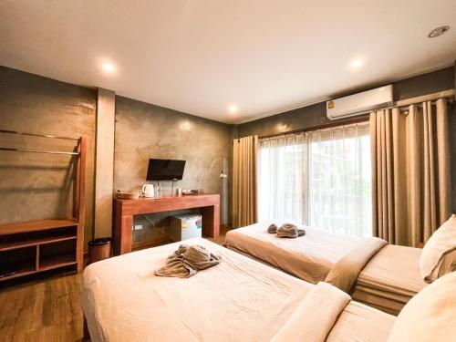 清迈BOSS HOTEL CHIANGMAl的酒店客房设有两张床和电视。