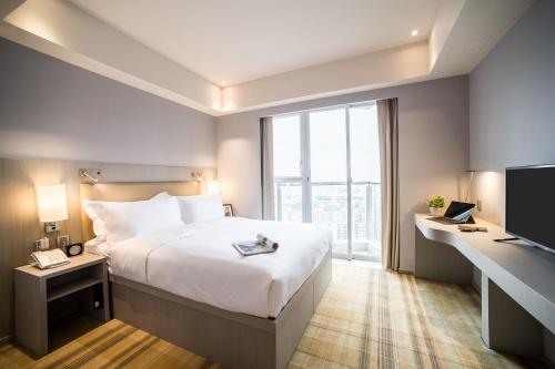 香港One Dundas的一间设有大床和窗户的酒店客房