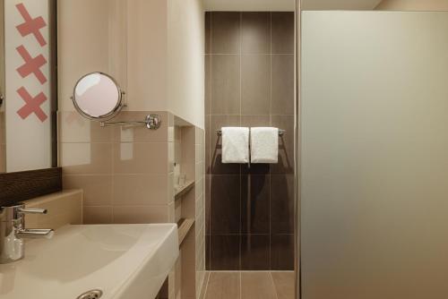 阿姆斯特丹阿姆斯特丹马诺尔酒店的带淋浴、水槽和镜子的浴室