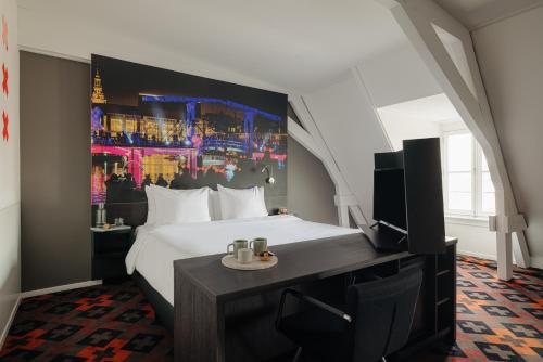 阿姆斯特丹阿姆斯特丹马诺尔酒店的一间酒店客房,配有一张床和一台电视