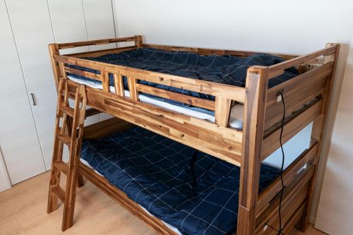 沼田Ittokashivacationrental nuevoL7 - Vacation STAY 83674v的一张带蓝色床垫的木制双层床