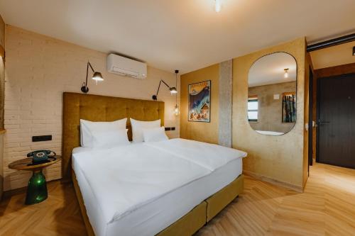 卢布尔雅那ONE66 Hotel的一张大白色的床,位于带镜子的房间里