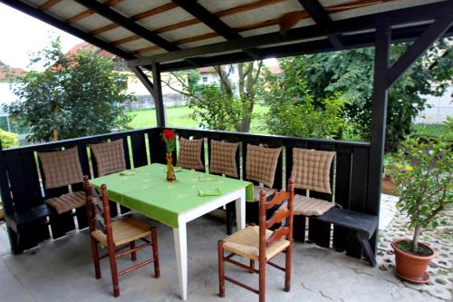 多姆扎莱Kmečka hiša Rodica的天井上摆放着绿色的桌椅