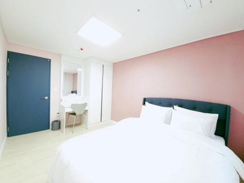 群山市Gunsan Little Prince Condo的一间卧室设有一张大床和一扇蓝色的门
