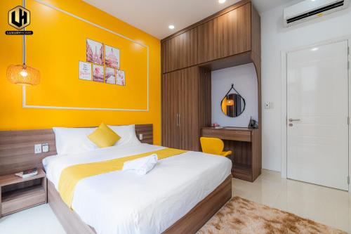 胡志明市Luxury Condotel Sai Gon 2的一间卧室设有一张床和黄色的墙壁