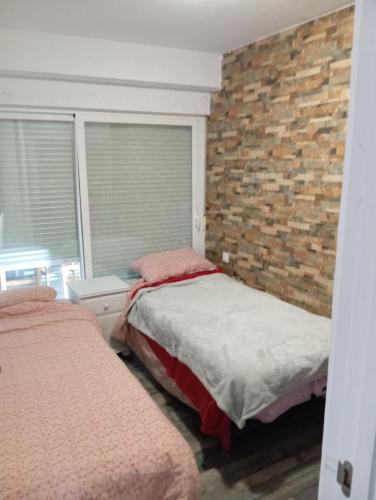 马盖鲁夫Villa Juanmi的一间卧室设有两张床和砖墙