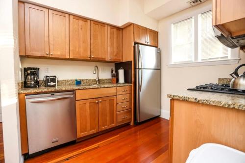 马尔登Stylish Apartment in Malden 20 Min from Boston #2的厨房配有木制橱柜和不锈钢冰箱。