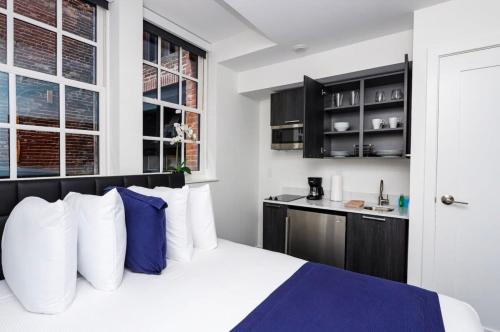 波士顿Modern Studio in Historic Boston - Garden Unit #4的一间卧室配有一张带白色和蓝色枕头的床