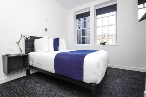 波士顿Stylish Studio in Fenway Neighborhood - Unit #306的一间卧室设有一张大床和两个窗户。