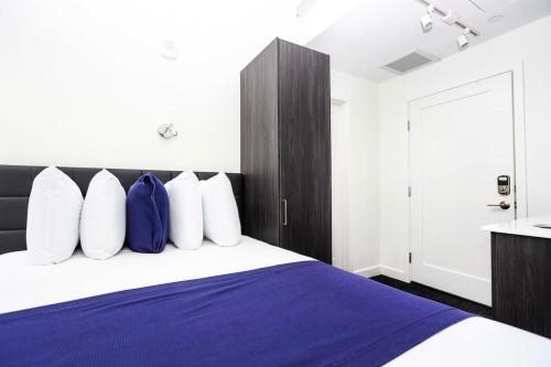 波士顿Stylish Studio in Historic Boston - Unit #404的一间卧室配有一张带蓝色和白色枕头的床