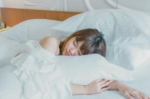 华欣G 华欣度假酒店及购物中心的睡在床上的女孩头戴枕头