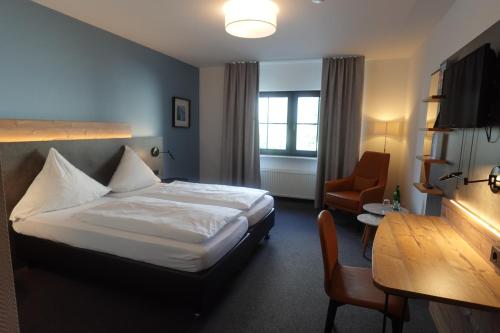 科布伦茨黑熊葡萄酒屋及酒店的配有一张床和一把椅子的酒店客房