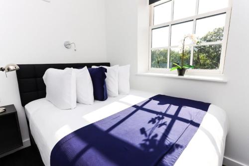 波士顿Modern Suite in Fenway Neighborhood的一间卧室配有一张带蓝白色毯子的床