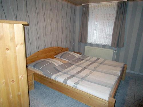 朗格内斯岛Ferienwohnung Uthlande的一间卧室配有一张木框床和窗户。