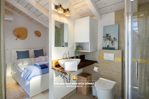 利纳迪奇Villa Ohana Krk的一间带水槽的浴室和一张位于客房内的床