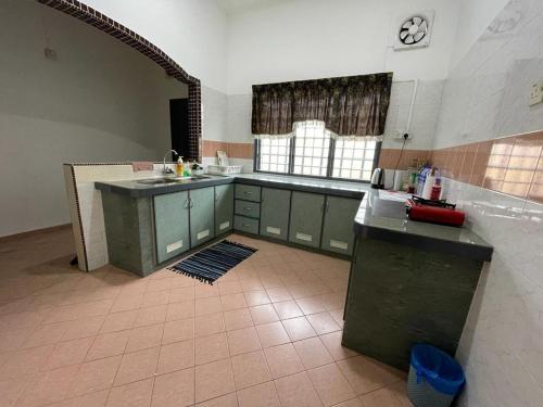 居銮My Delima Home for MusIim的一间厨房,配有绿色橱柜和瓷砖地板